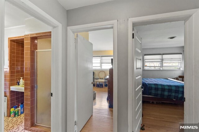 corridor with wood finished floors and a healthy amount of sunlight