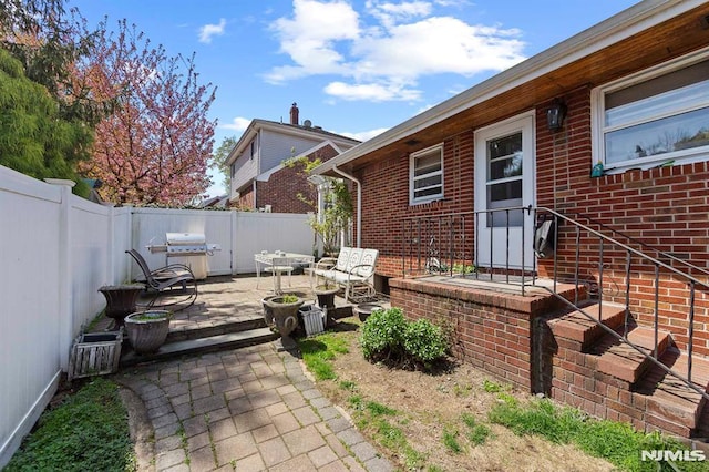 view of patio with grilling area and a fenced backyard
