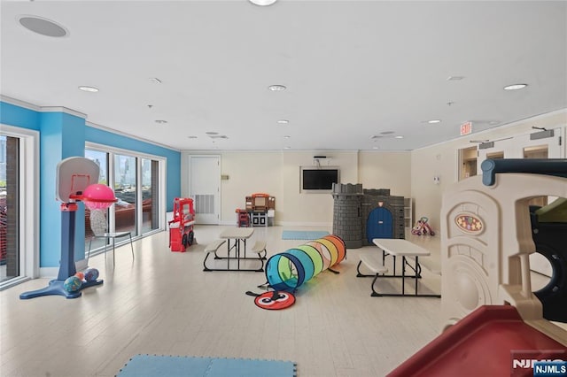 playroom with wood finished floors, recessed lighting, crown molding, and baseboards