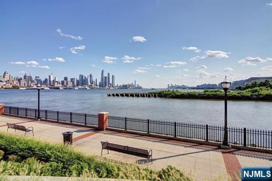 view of water feature featuring fence and a city view