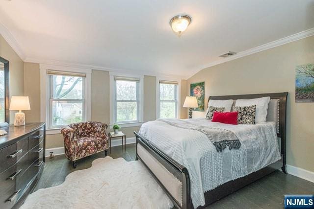 bedroom with ornamental molding, visible vents, wood finished floors, and baseboards