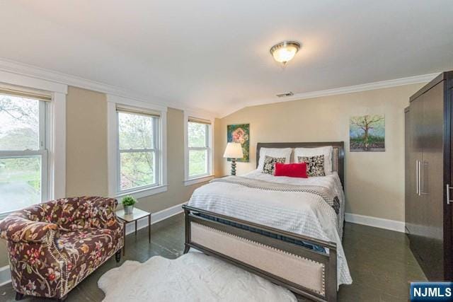bedroom featuring baseboards, multiple windows, and vaulted ceiling