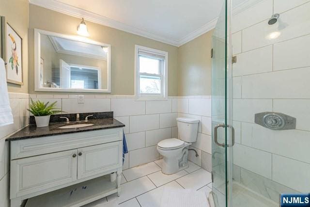 bathroom with vanity, toilet, a stall shower, ornamental molding, and tile patterned flooring