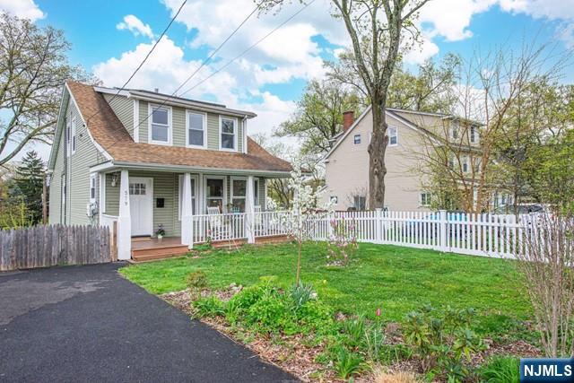 bungalow-style house with covered porch, fence, and a front yard