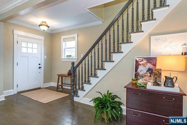 entryway featuring baseboards, ornamental molding, stairs, and wood finished floors