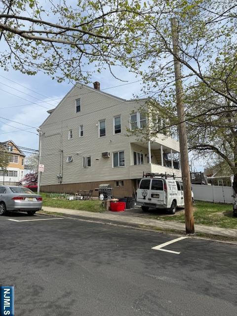 view of building exterior with fence and uncovered parking