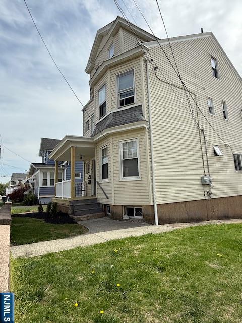 view of home's exterior with a porch and a yard