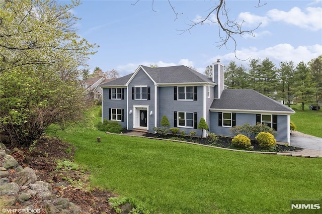 colonial-style house with a chimney and a front lawn