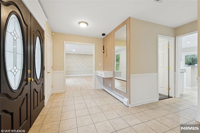 foyer entrance featuring a baseboard heating unit and light tile patterned flooring