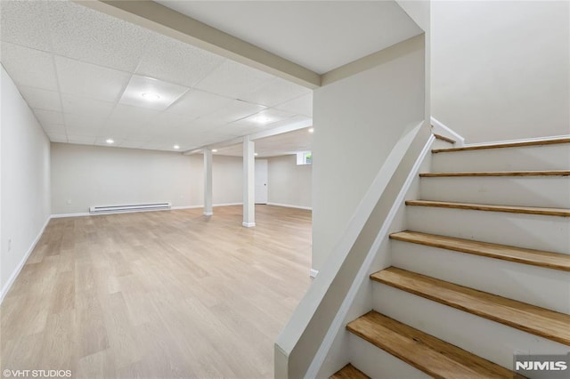 stairway with baseboard heating, baseboards, a drop ceiling, recessed lighting, and wood finished floors