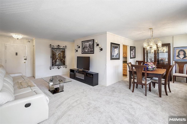 living area featuring ornamental molding, carpet, a textured ceiling, and a notable chandelier