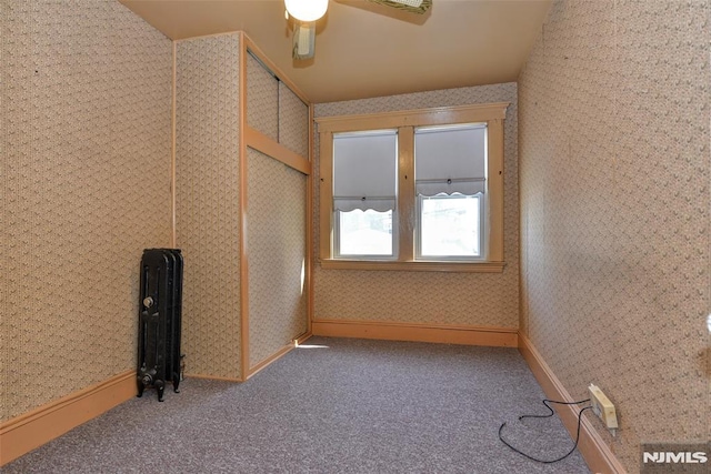 unfurnished room with carpet flooring, a ceiling fan, and wallpapered walls