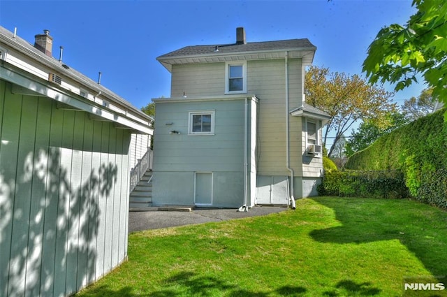 rear view of property with a yard and a chimney