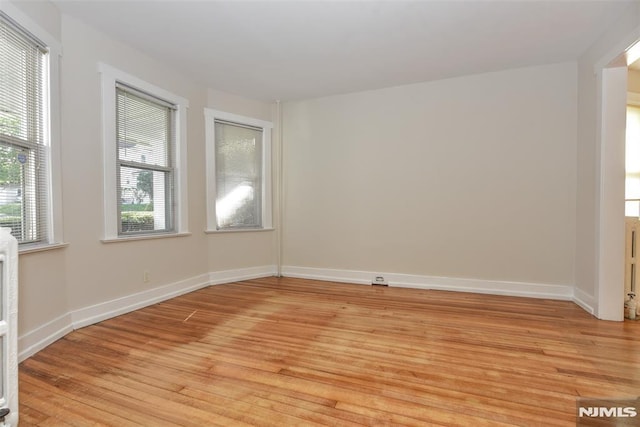 spare room with light wood-style floors and baseboards