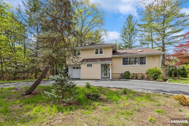 split level home with an attached garage and driveway