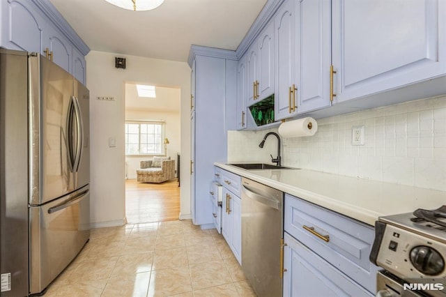 kitchen featuring light countertops, tasteful backsplash, a sink, light tile patterned floors, and stainless steel appliances