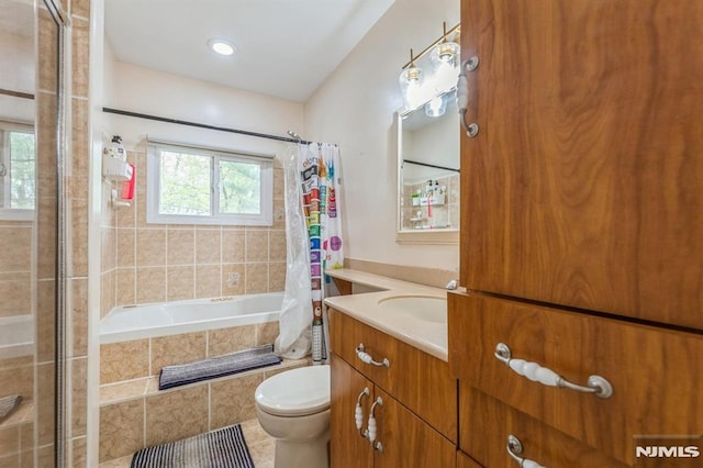bathroom featuring vanity, tile patterned floors, toilet, and tiled shower / bath