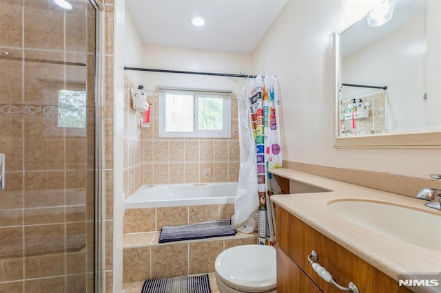 bathroom featuring recessed lighting, vanity, toilet, and tiled shower / bath combo