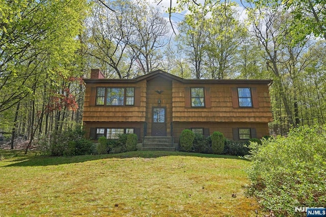 bi-level home featuring a chimney and a front yard