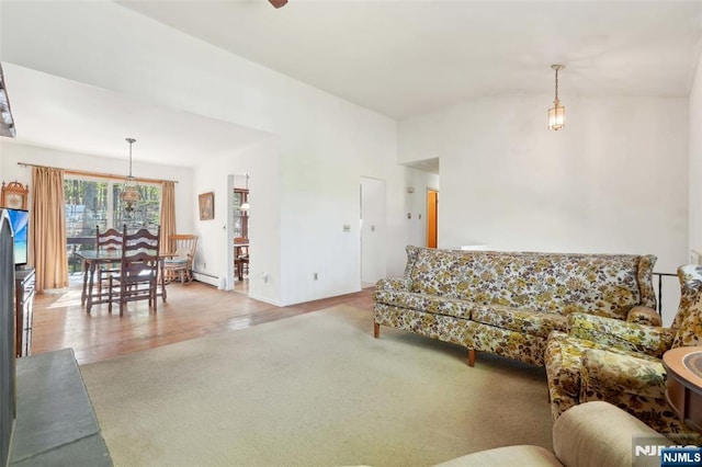 living area featuring vaulted ceiling, baseboard heating, carpet flooring, and wood finished floors