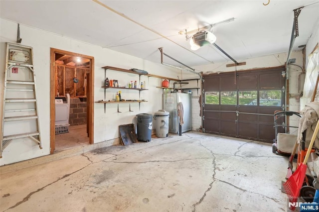 garage with water heater, a garage door opener, and washer / dryer