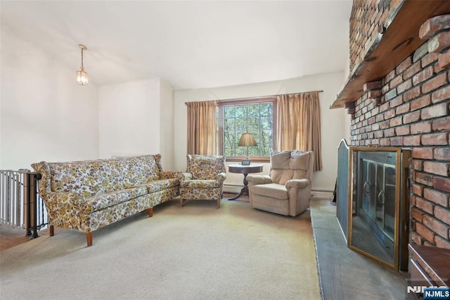 living area with a brick fireplace and carpet