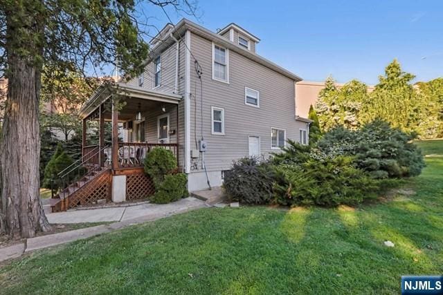 view of home's exterior with a yard, stairway, and covered porch
