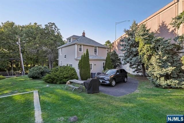 back of property featuring a yard and a chimney