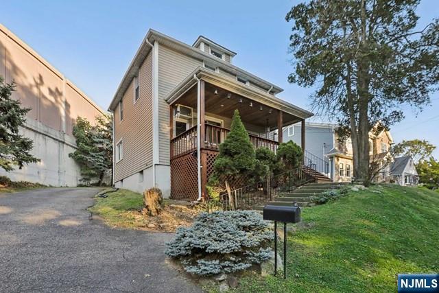 view of front of home with stairs and a front lawn