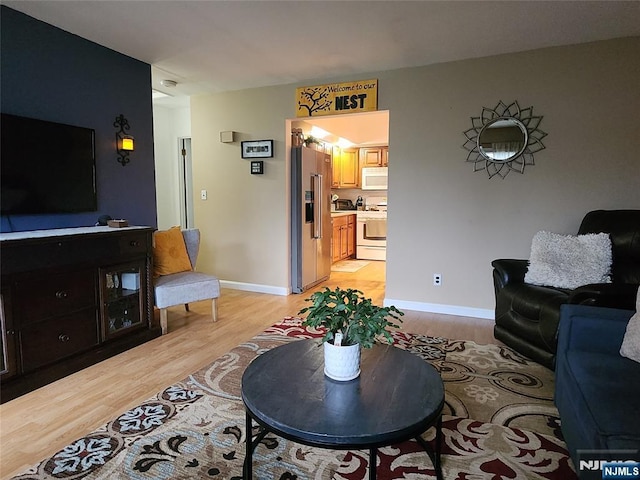 living area featuring light wood finished floors and baseboards