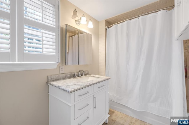 full bath with wood finished floors, shower / bath combo, and vanity