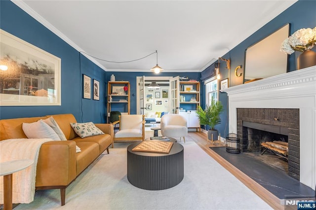 living room with ornamental molding, wood finished floors, and a fireplace