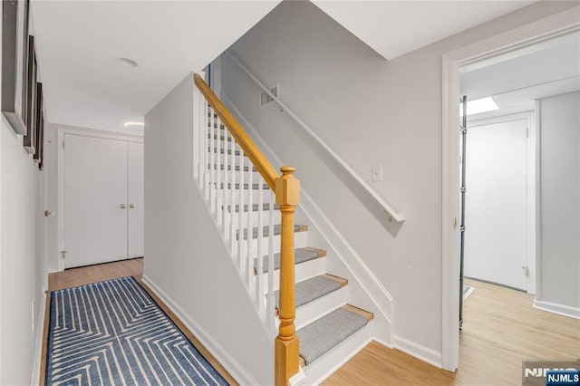 stairway with baseboards and wood finished floors