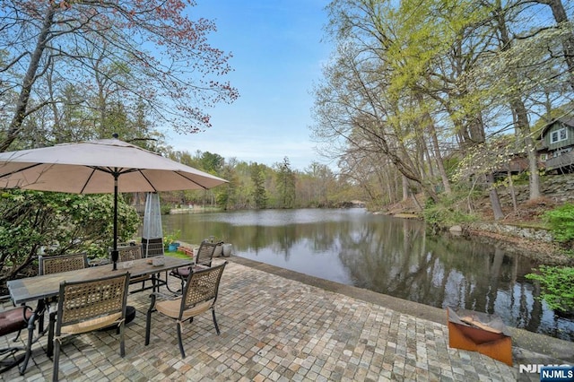 exterior space with a patio, a water view, and outdoor dining space