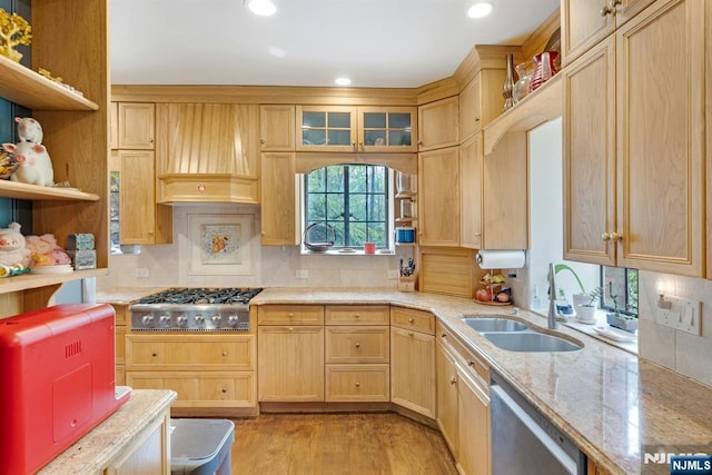 kitchen with open shelves, light brown cabinetry, premium range hood, a sink, and appliances with stainless steel finishes