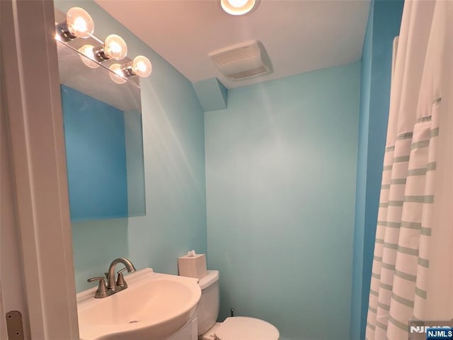full bathroom featuring visible vents, a sink, curtained shower, and toilet