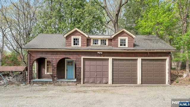 view of front of property with a shingled roof, a porch, and driveway