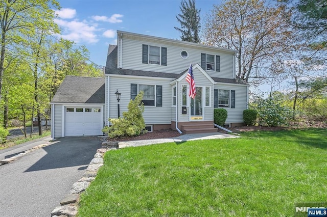 view of front facade with a front lawn, driveway, an attached garage, and roof with shingles