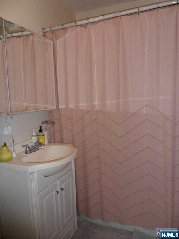 bathroom with tasteful backsplash and vanity
