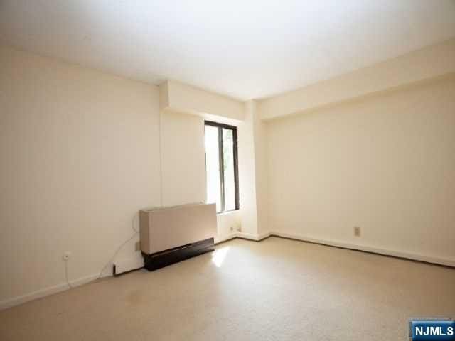 empty room featuring radiator heating unit and baseboards