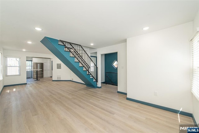 unfurnished living room featuring baseboards, recessed lighting, stairway, and light wood-type flooring