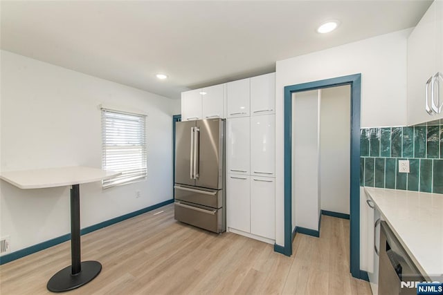 kitchen with light countertops, white cabinets, light wood-style floors, stainless steel appliances, and recessed lighting