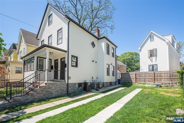 view of side of home featuring a lawn, fence, and a chimney