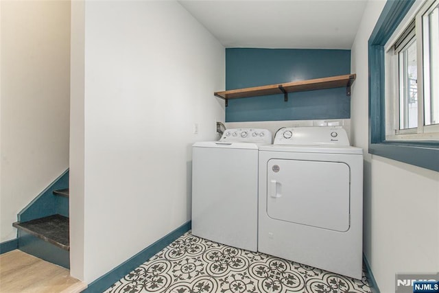 clothes washing area with separate washer and dryer, laundry area, and baseboards