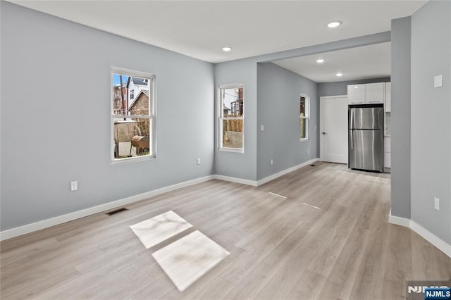 unfurnished room featuring recessed lighting, baseboards, visible vents, and light wood finished floors
