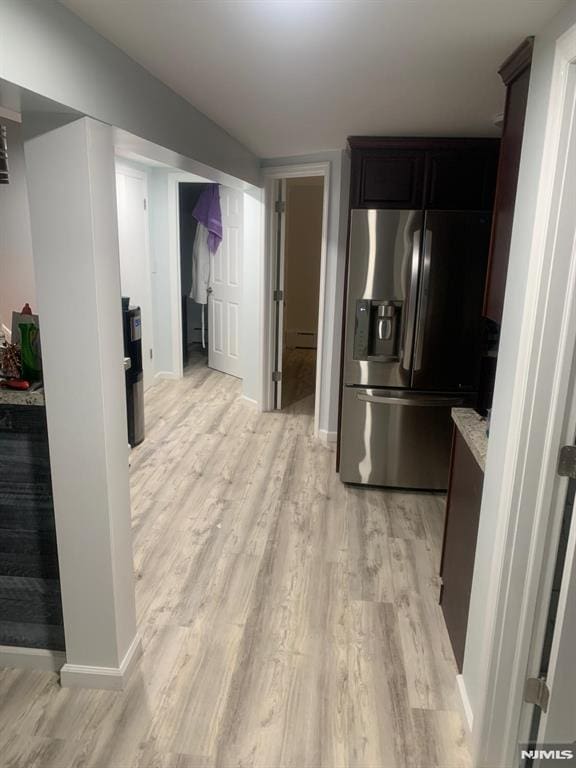 kitchen with light countertops, stainless steel fridge with ice dispenser, baseboards, and light wood-type flooring