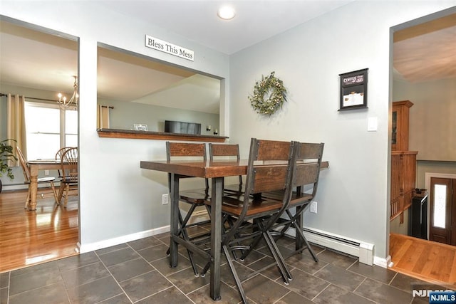dining area with an inviting chandelier, baseboards, a baseboard radiator, and dark tile patterned flooring