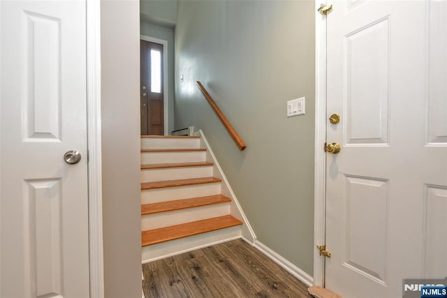 staircase with baseboards and wood finished floors