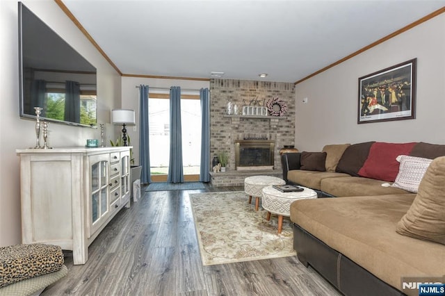 living area featuring ornamental molding, dark wood-style flooring, and a brick fireplace