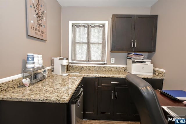 kitchen featuring stainless steel dishwasher and light stone counters